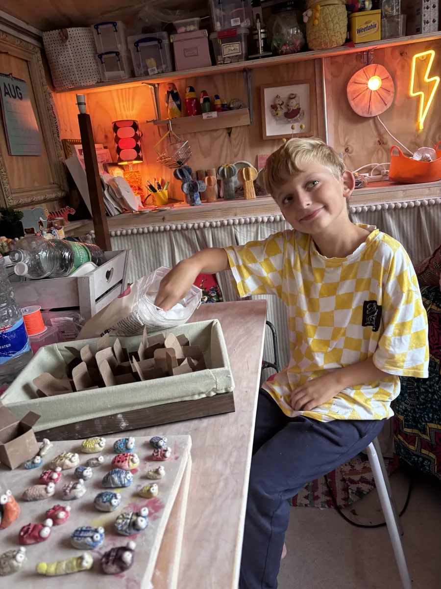 Gemma's son packing up the little clay bugs in the studio shed
