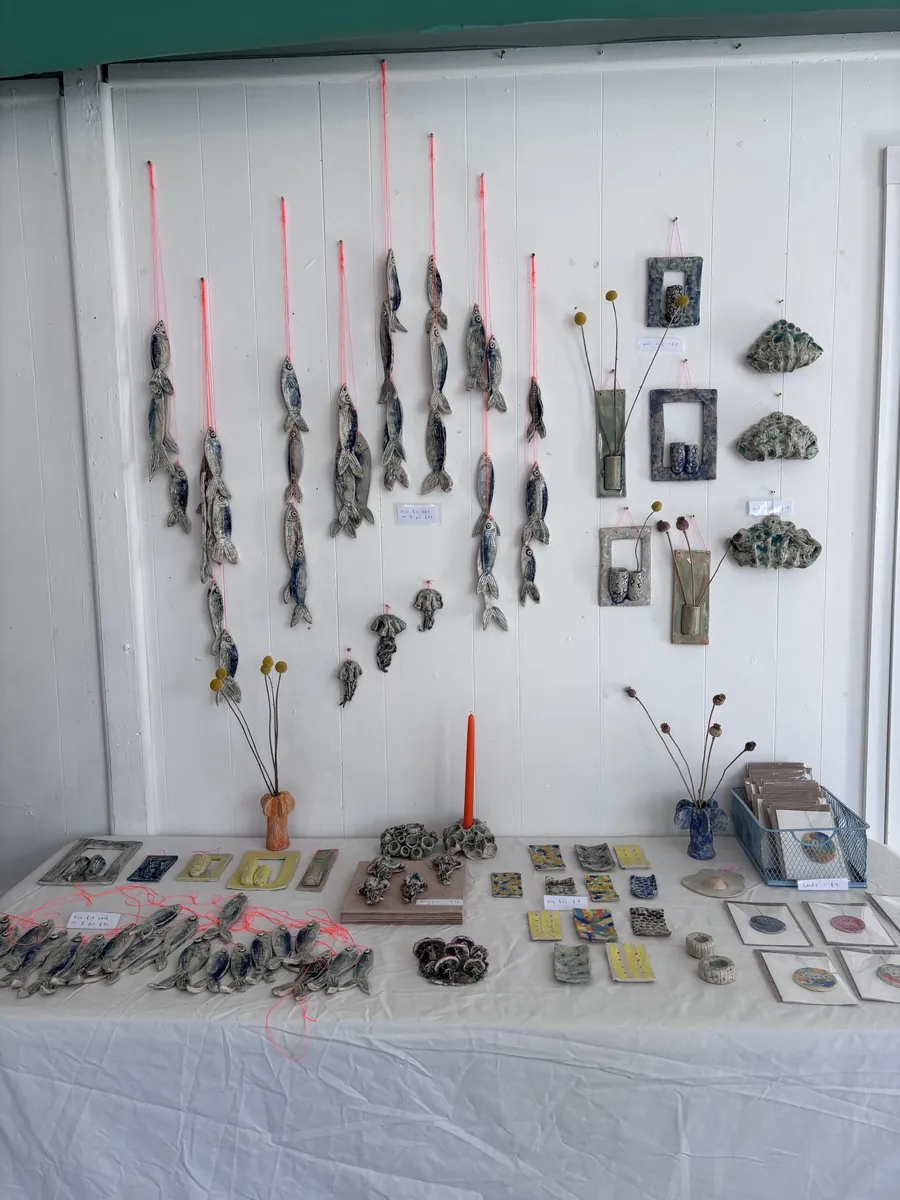 Hanging blue sardine strings, wall vases and soap dishes on a market stall