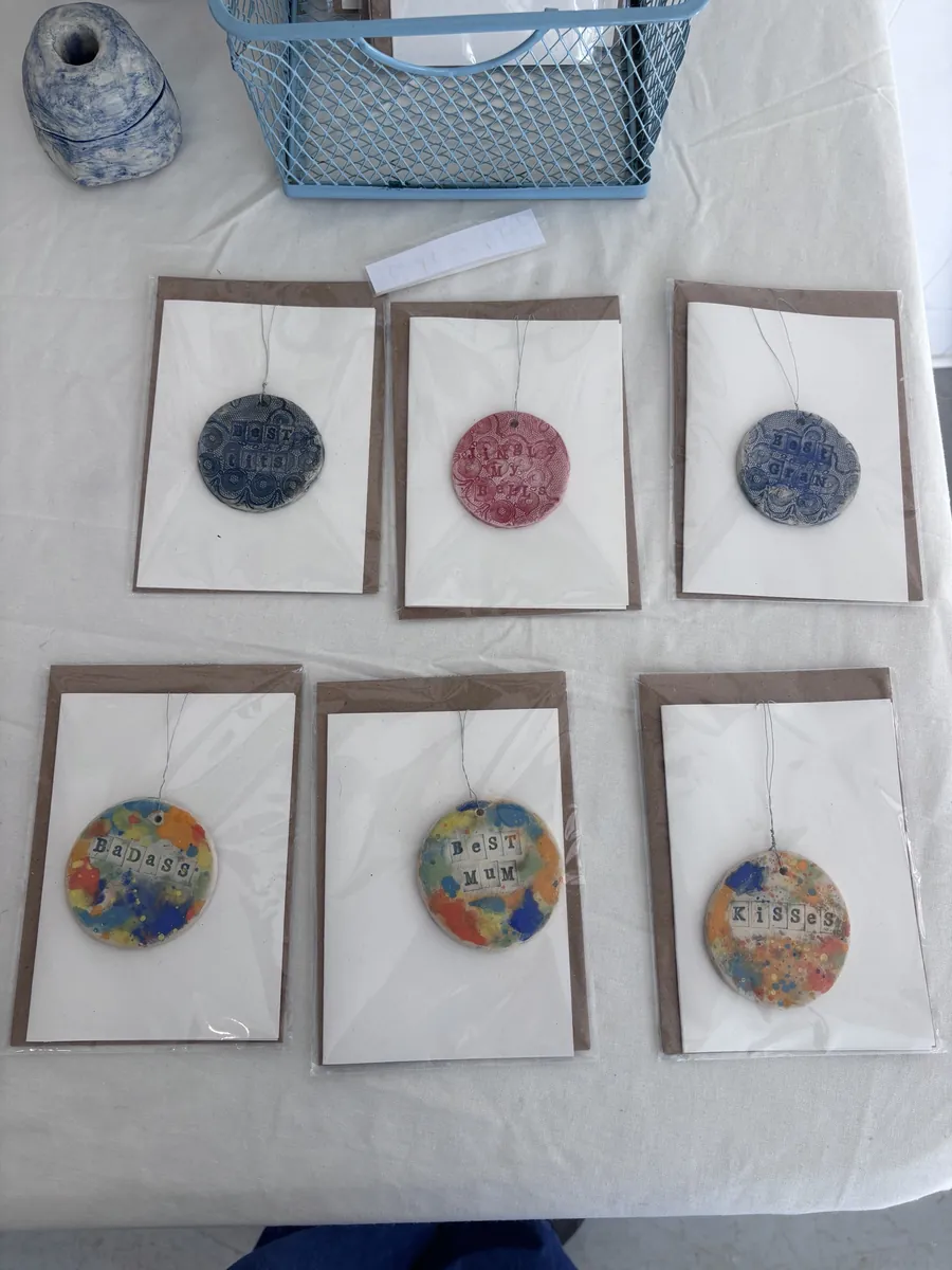 Stamped ceramic hanging discs mounted on greetings cards
