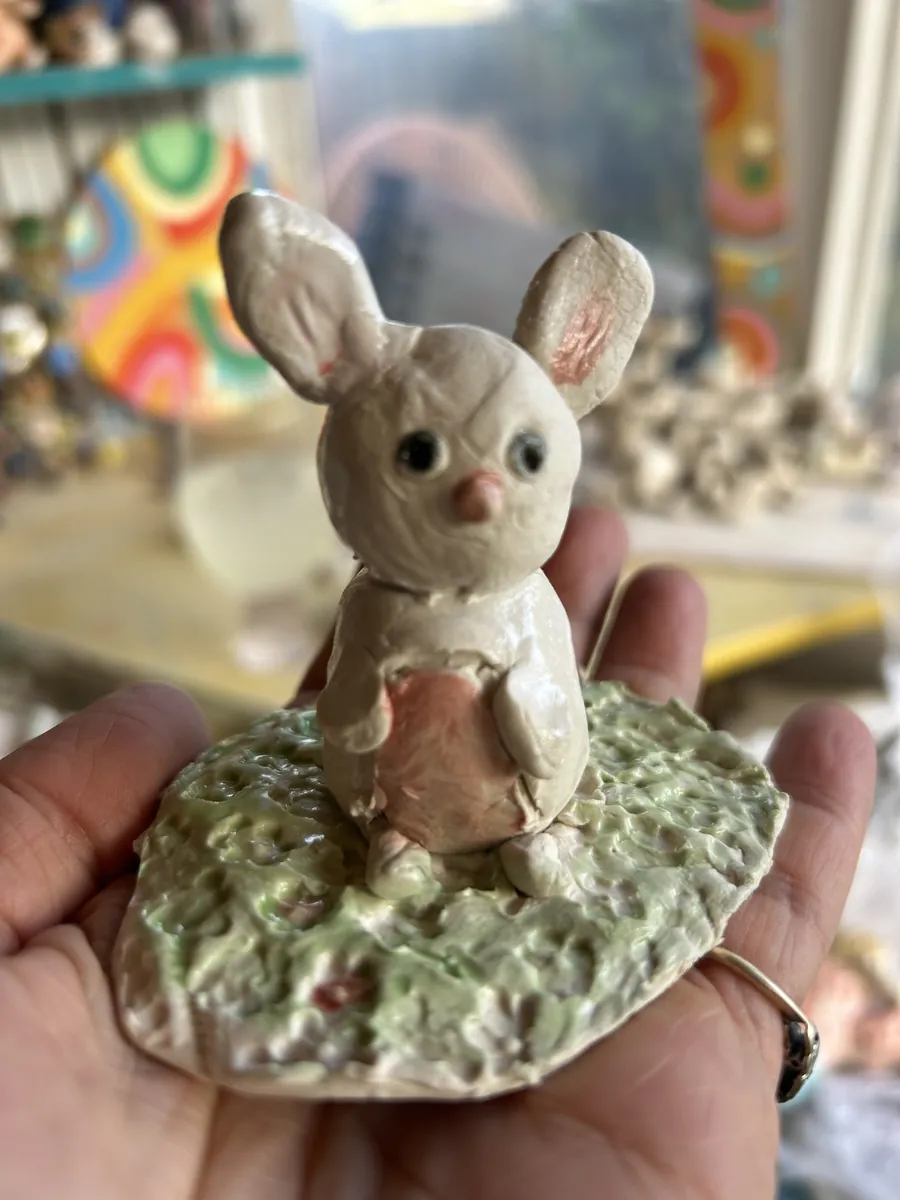 A white bunny standing on a green grassy base