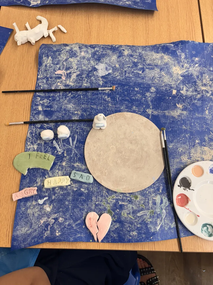 Clay word tiles reading I feel happy, sad and angry, with a pink heart