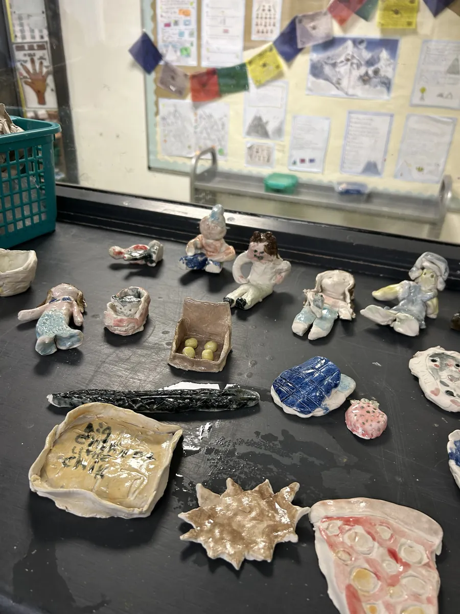 Glazed clay figures, a mermaid, pizza slice and sun dish