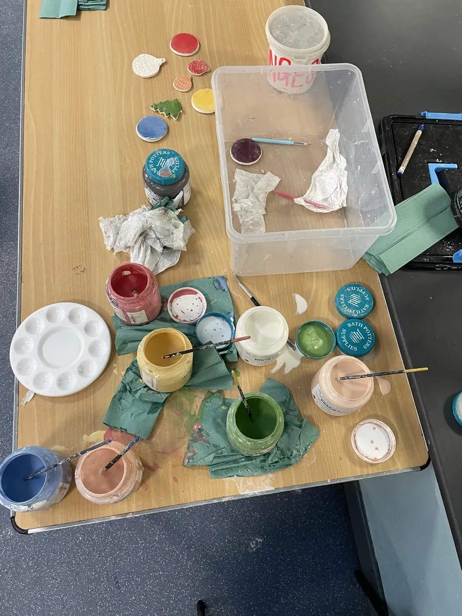 Pots of underglaze and painted Christmas decorations on a table