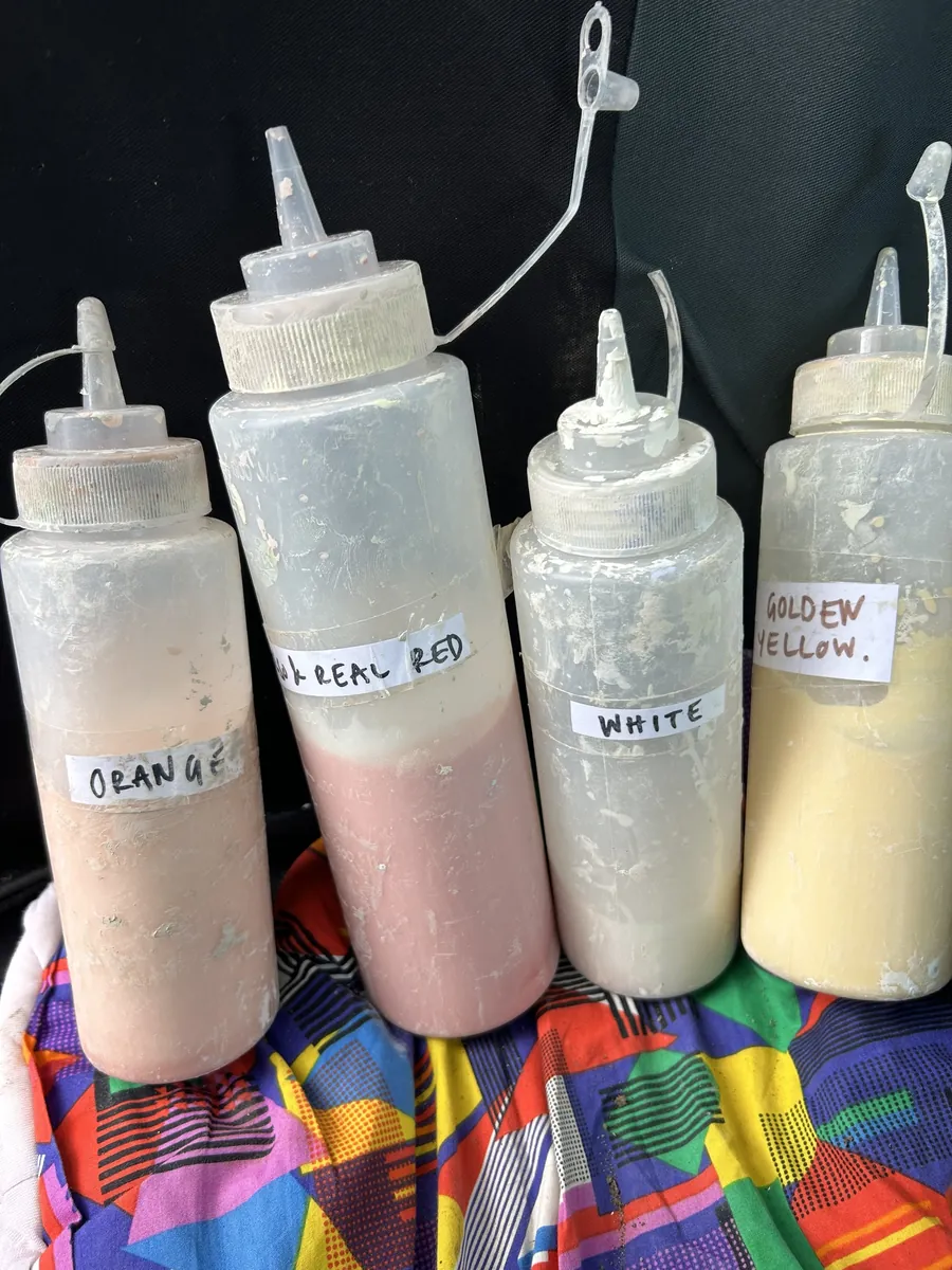 Bottles of orange, red, white and golden yellow glaze