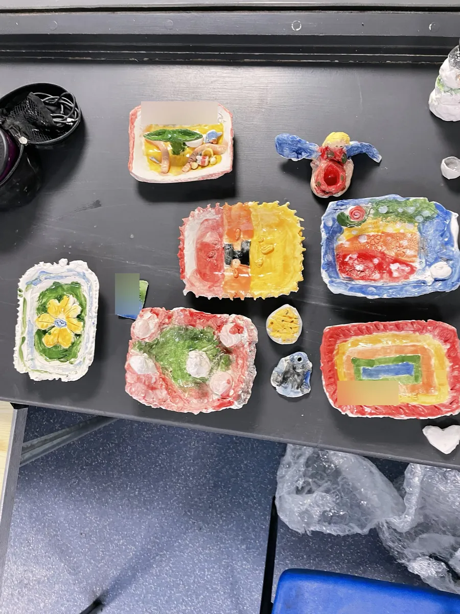 Brightly glazed dishes, a flower dish and a winged angel