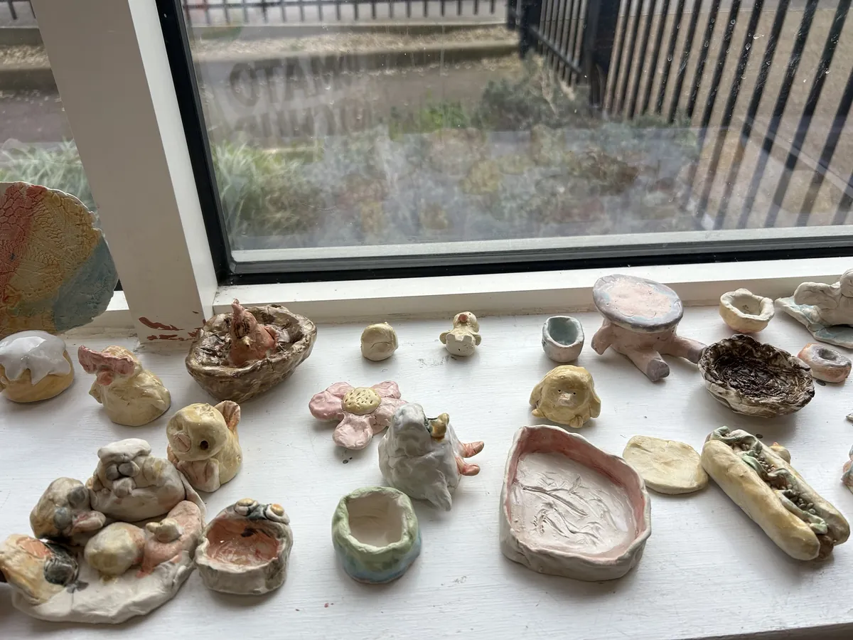 Children's finished pieces lined up along a classroom windowsill