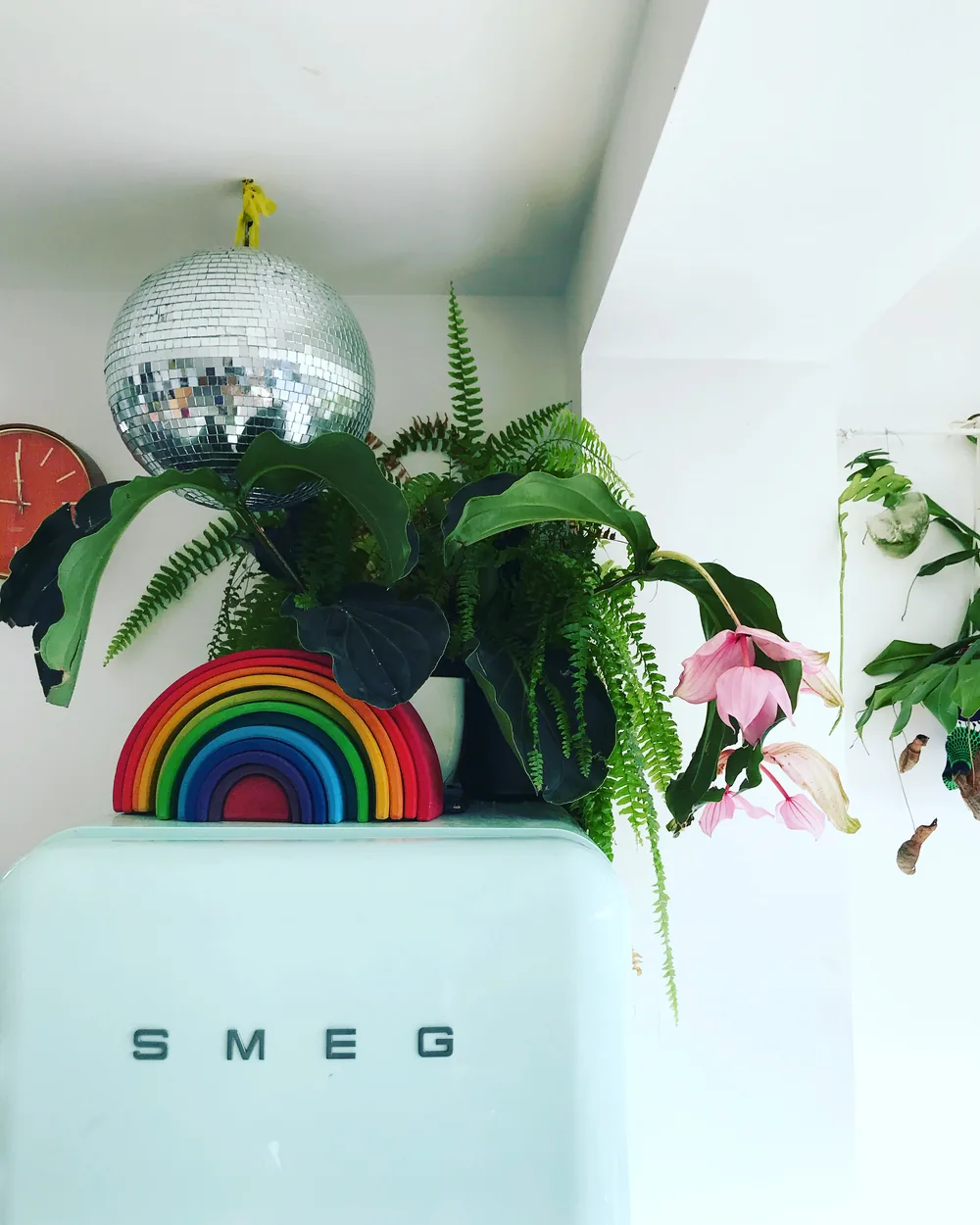 Kitchen corner with a mint Smeg fridge, rainbow stacker, disco ball and trailing ferns