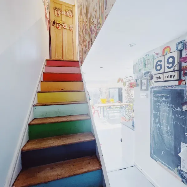Rainbow-painted stairs below a botanical mural