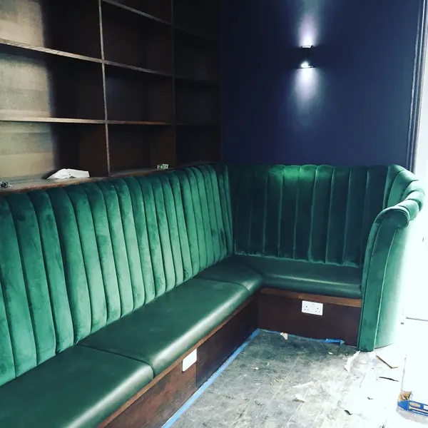 A fluted emerald velvet banquette