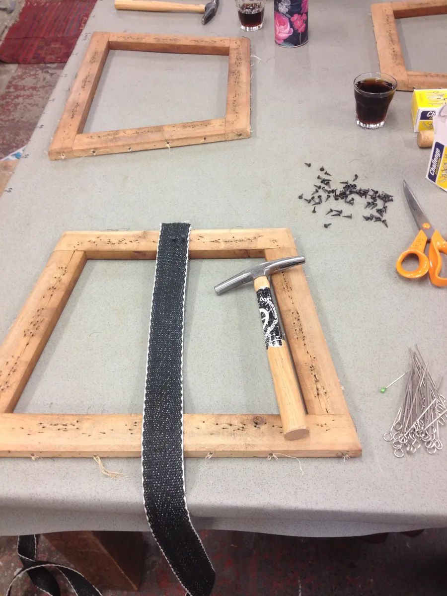 Webbing a seat frame with a magnetic tack hammer and upholstery tacks
